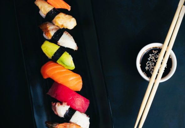 Sushi on a black plate.